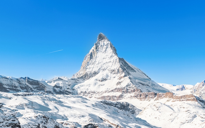 Matterhorn Peak covered in snow under a clear blue sky, Swiss Alps.