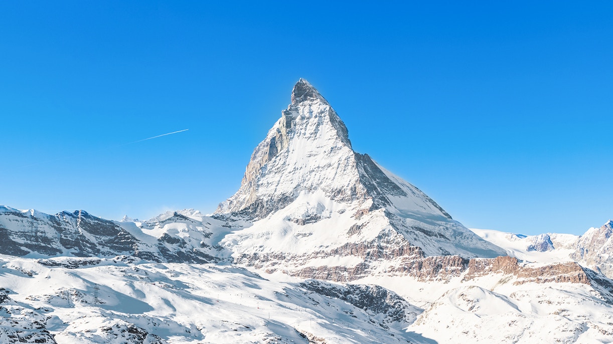 Matterhorn Peak covered in snow under a clear blue sky, Swiss Alps.