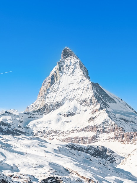 Matterhorn Peak covered in snow under a clear blue sky, Swiss Alps.