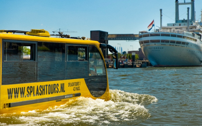 Yellow amphibious bus on Rotterdam waterway during 1-hour sightseeing splash tour.