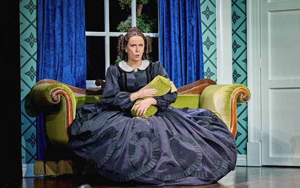 Stage scene from Oh, Mary Westend show with actor in period costume on a vintage sofa.
