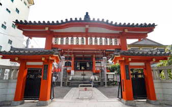 Entrance to a traditional Japanese temple in Tokyo, featuring red gates and lanterns.