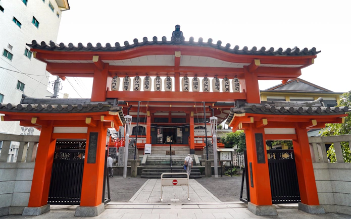 Entrance to a traditional Japanese temple in Tokyo, featuring red gates and lanterns.