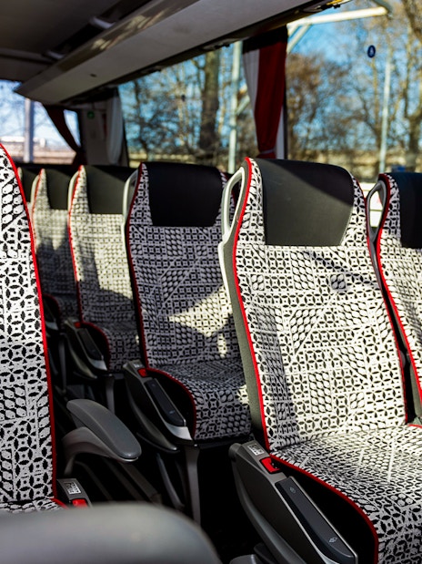SIT Bus Shuttle seats with patterned upholstery and armrests.