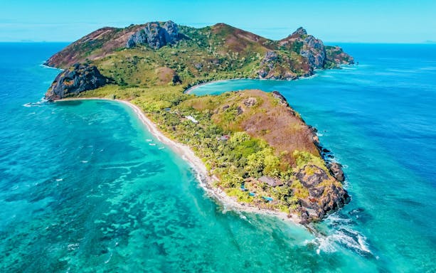 Aerial view of Kuata Island resort with lush greenery and turquoise waters, Fiji.