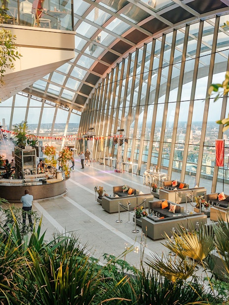 Sky Garden London interior with evening city views and lush greenery.
