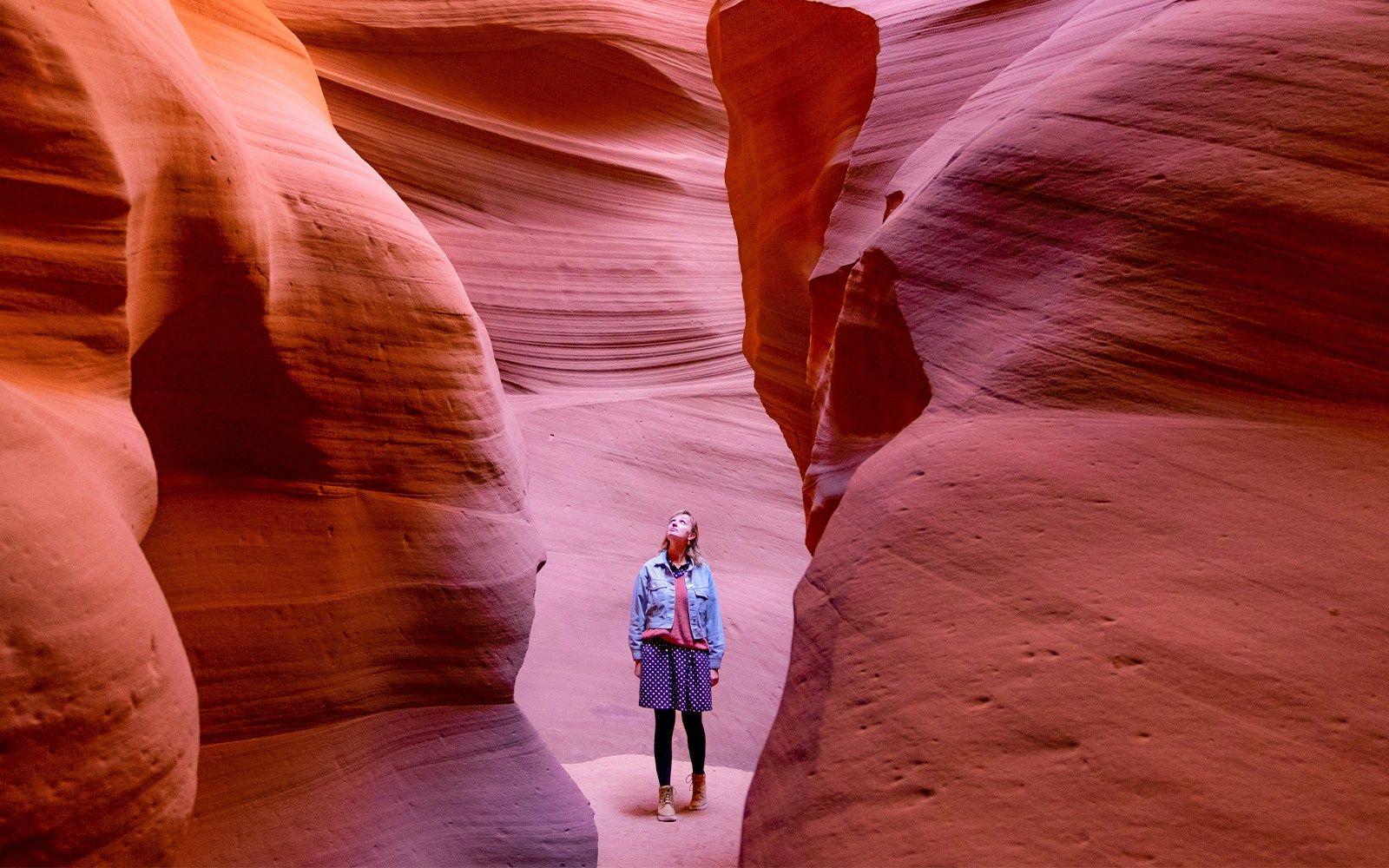 Visitor exploring the narrow sandstone walls of Antelope Canyon.