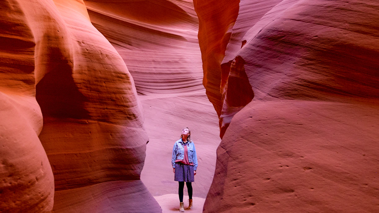 Visitor exploring the narrow sandstone walls of Antelope Canyon.