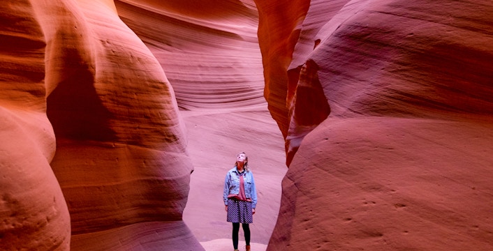 Visitor exploring the narrow sandstone walls of Antelope Canyon.