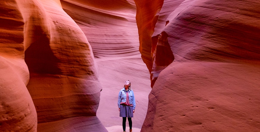 Visitor exploring the narrow sandstone walls of Antelope Canyon.