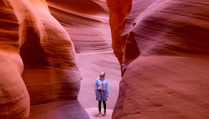 Visitor exploring the narrow sandstone walls of Antelope Canyon.