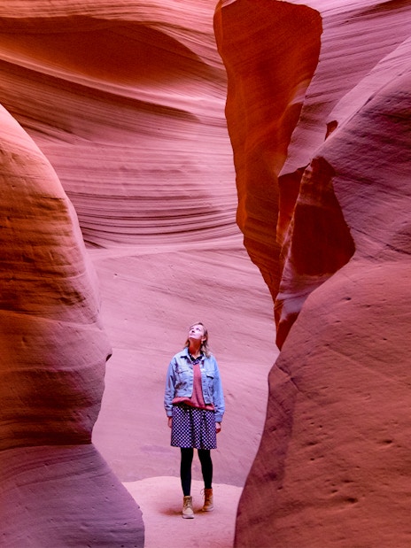 Visitor exploring the narrow sandstone walls of Antelope Canyon.