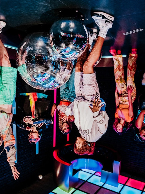 Visitors interacting with mirrored disco balls at Upside Down Amsterdam.