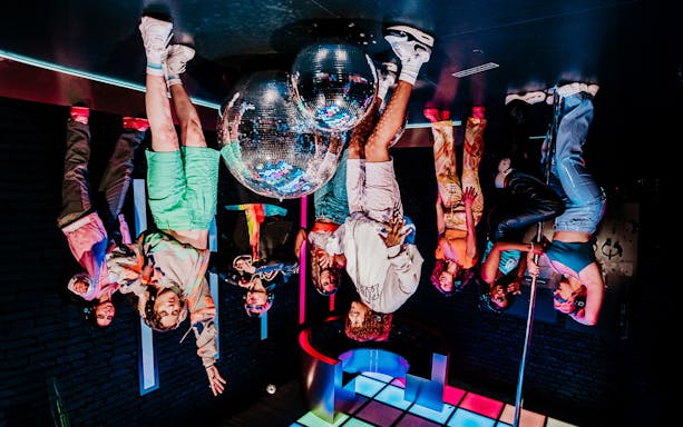 Visitors interacting with mirrored disco balls at Upside Down Amsterdam.