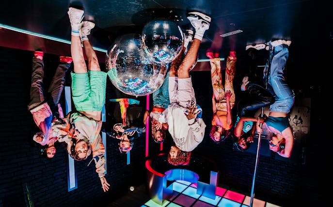 Visitors interacting with mirrored disco balls at Upside Down Amsterdam.