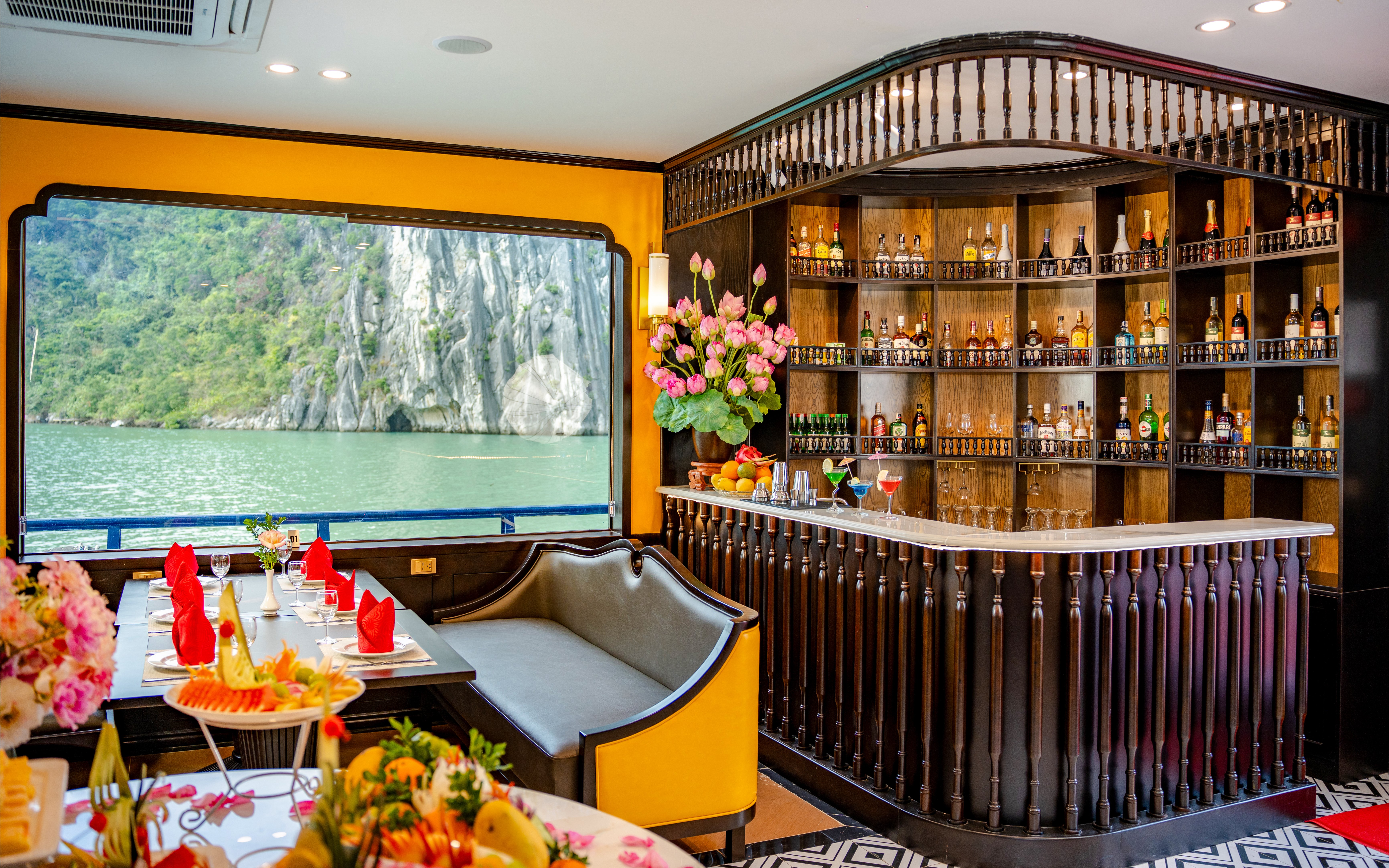 Phong Hai Harmony Cruise interior with dining table, bar, and scenic window view.