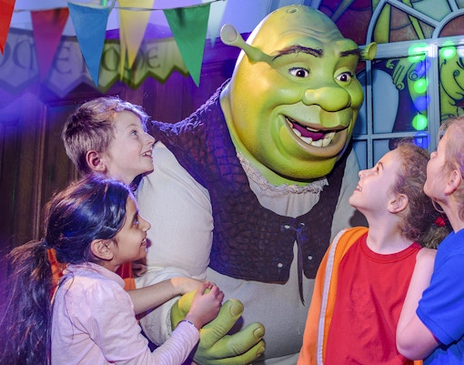 Children interacting with Shrek at Shrek's Adventure in London.