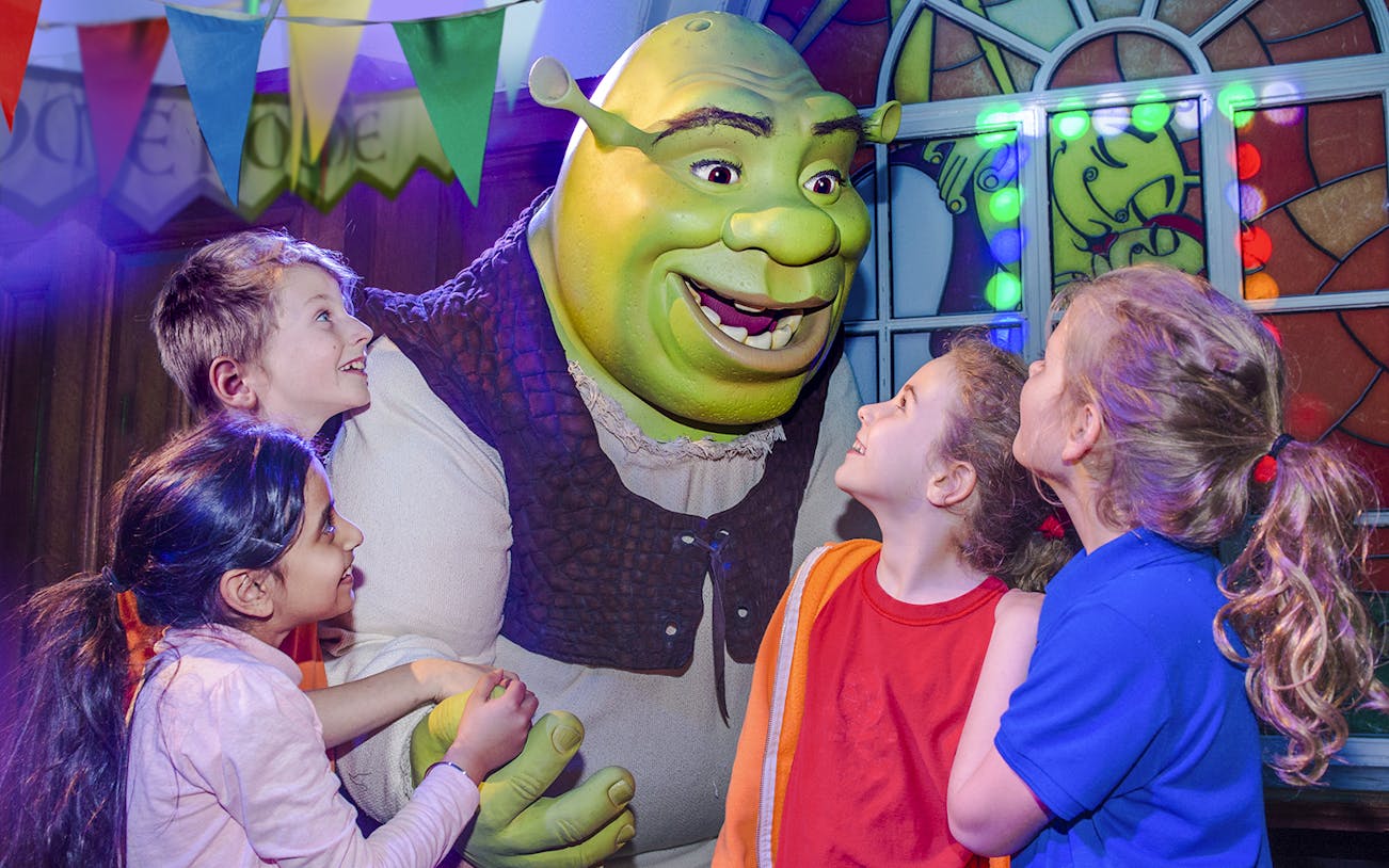 Children interacting with Shrek at Shrek's Adventure in London.