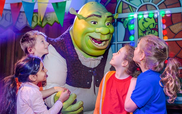 Children interacting with Shrek at Shrek's Adventure in London.