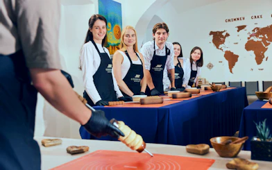 Participants at a Chimney Cake Workshop in Budapest preparing Kürtőskalács.