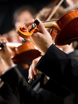 Musicians playing violins at a concert in Hofburg Vienna.