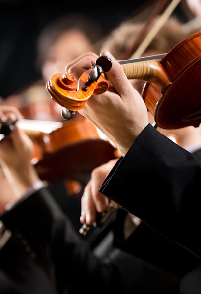 Musicians playing violins at a concert in Hofburg Vienna.