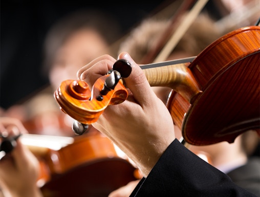 Musicians playing violins at a concert in Hofburg Vienna.