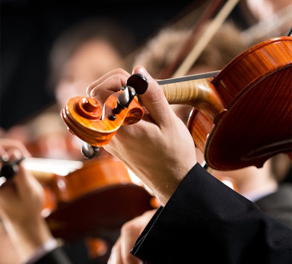 Musicians playing violins at a concert in Hofburg Vienna.