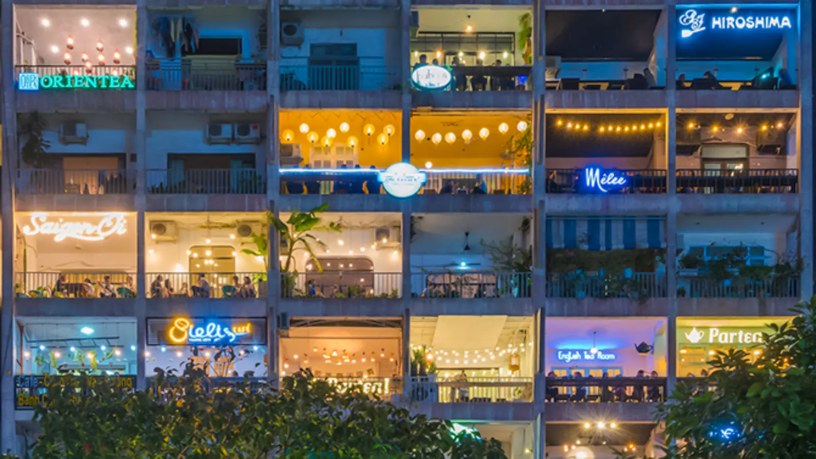 Night view of illuminated cafes and restaurants in a Saigon building, Ho Chi Minh City.