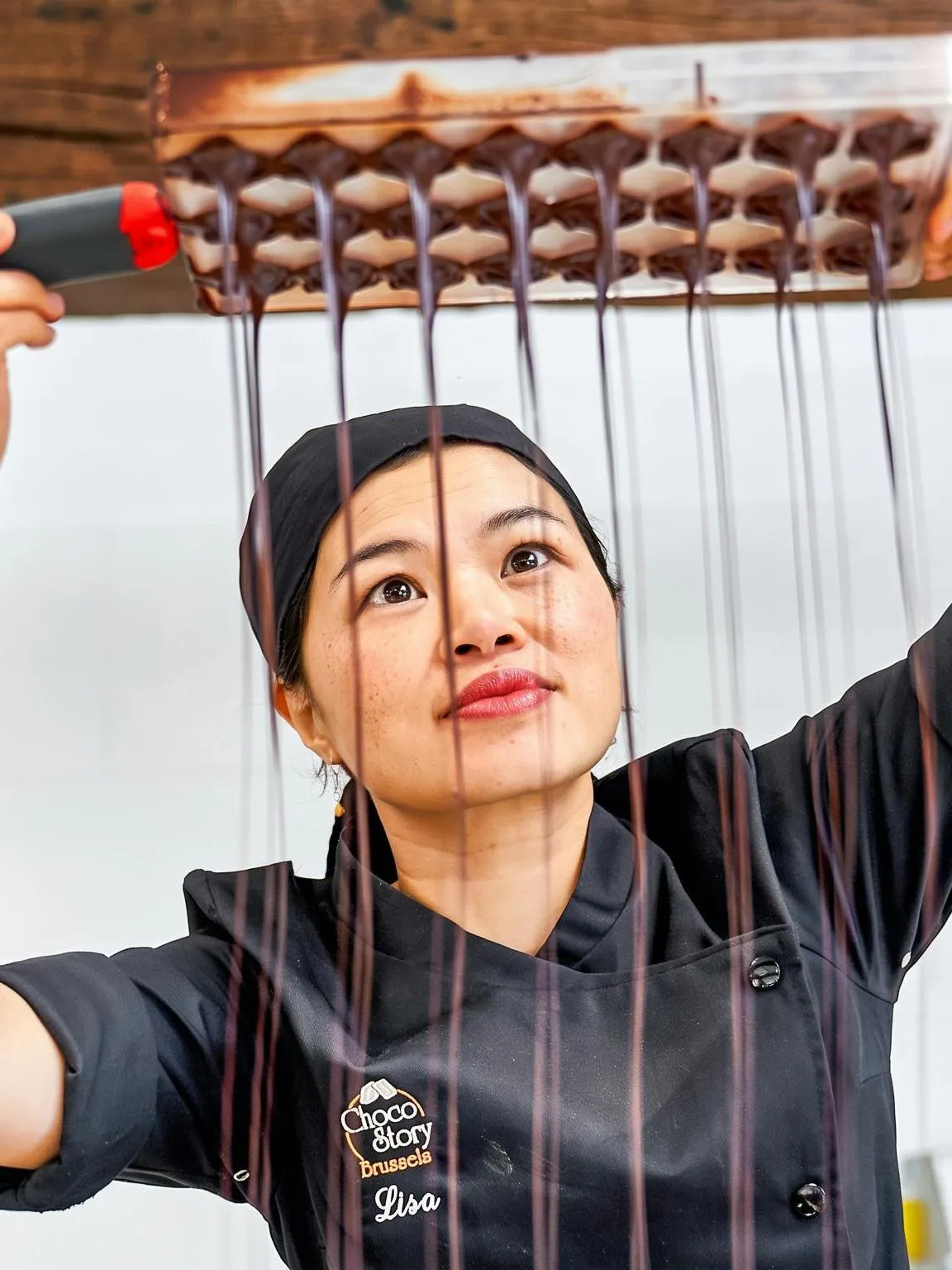 Chocolate maker demonstrating chocolate pouring at Choco Story Brussels.
