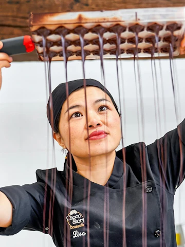 Chocolate maker demonstrating chocolate pouring at Choco Story Brussels.