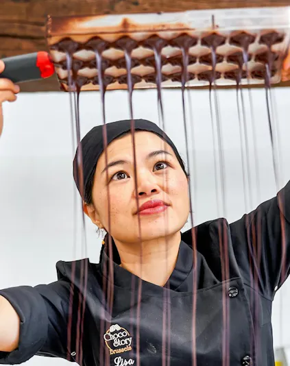 Chocolate maker demonstrating chocolate pouring at Choco Story Brussels.