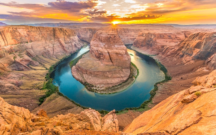 Aerial view of Horseshoe Bend at sunset, showcasing the Colorado River's curve in Arizona.