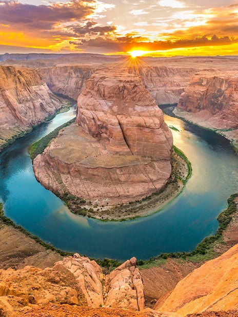 Aerial view of Horseshoe Bend at sunset, showcasing the Colorado River's curve in Arizona.
