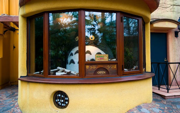 Totoro figure behind glass at Studio Ghibli Museum ticket booth, Japan.