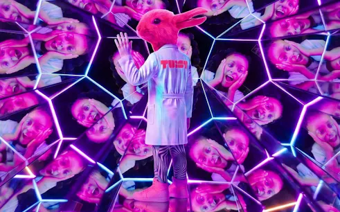 Guest in a rabbit costume at Twist Museum London, surrounded by mirrored reflections.