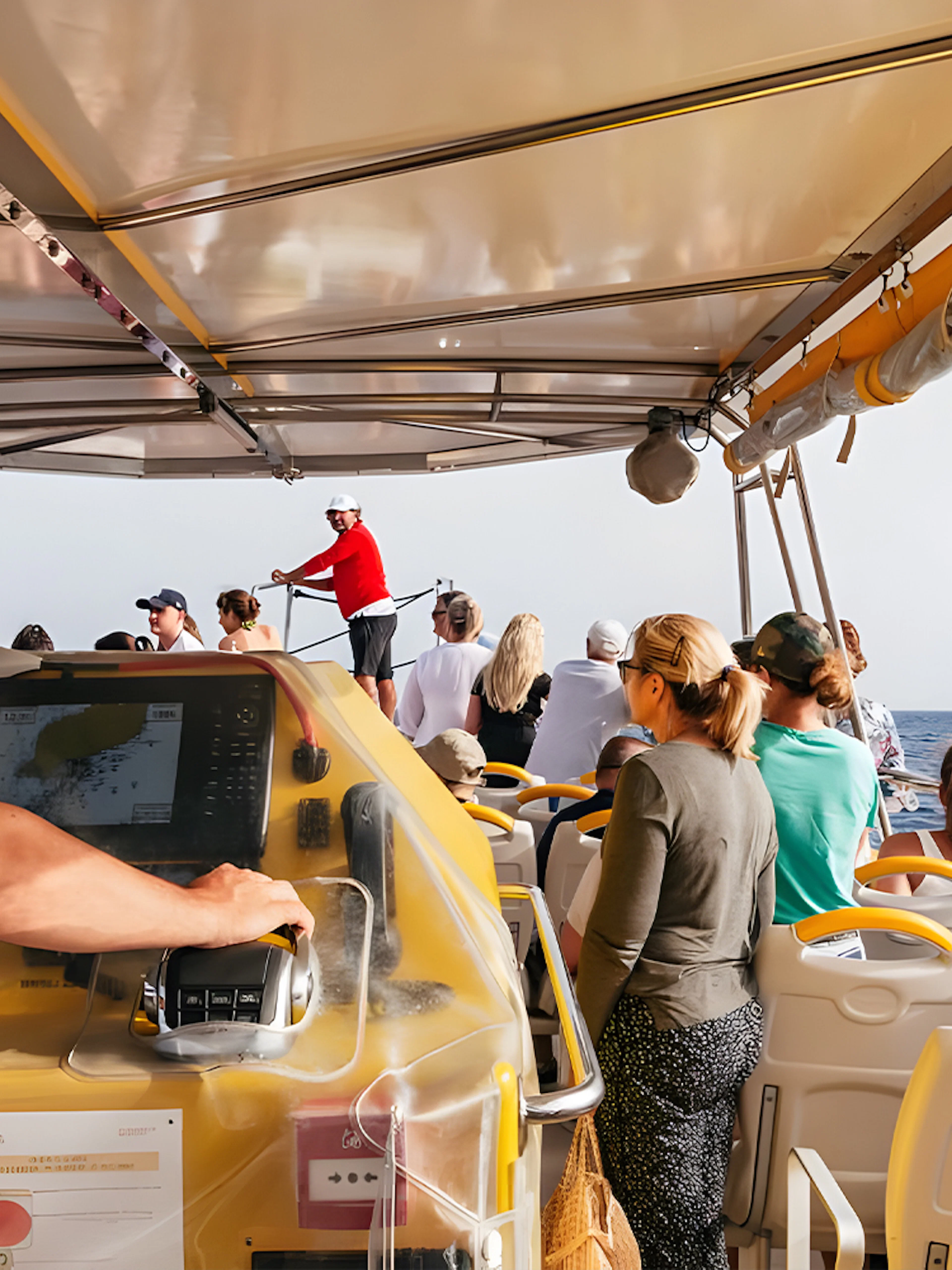 Tourists on a speedboat during a sunset dolphin cruise, with a guide steering the boat.