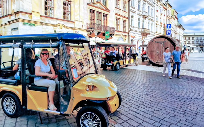 Golf cart tour in Krakow Old Town with historic buildings in the background.
