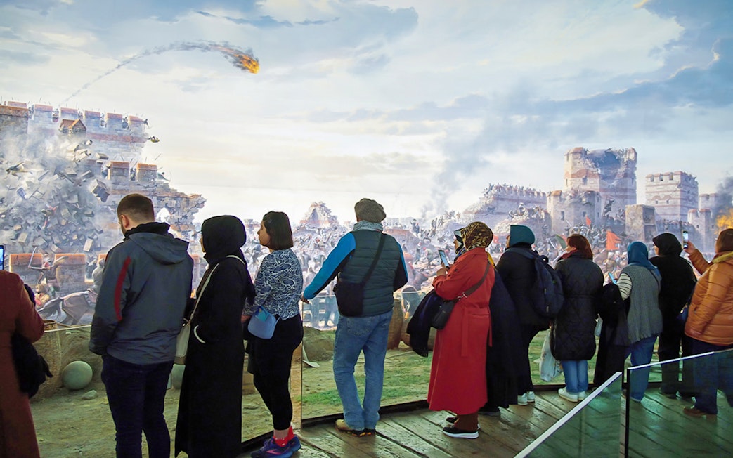 Visitors viewing the battle diorama at Istanbul Panorama 1453 History Museum.