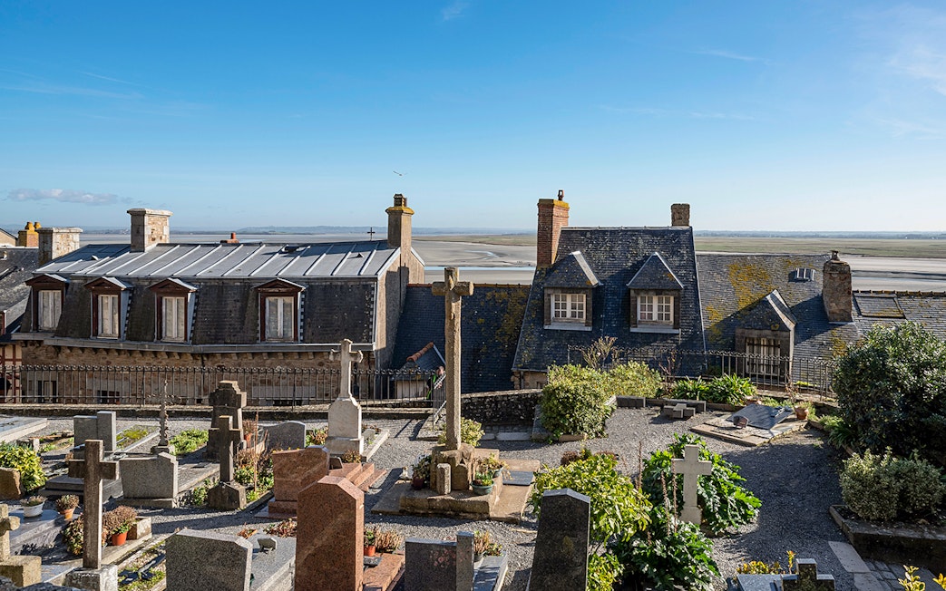 Rooftop view of Mont-Saint-Michel Abbey with surrounding landscape.