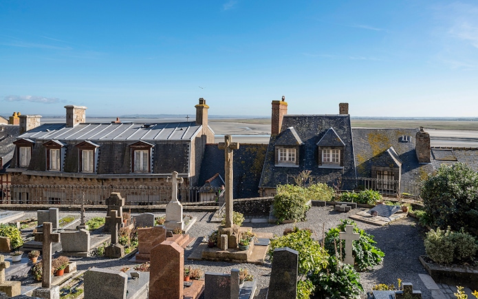Rooftop view of Mont-Saint-Michel Abbey with surrounding landscape.