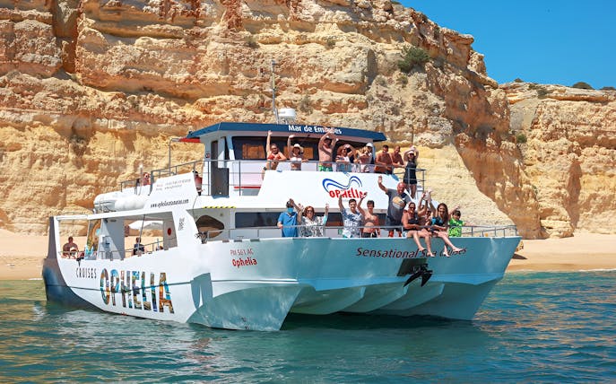 Catamaran with tourists near Benagil Caves, Portimão coast.