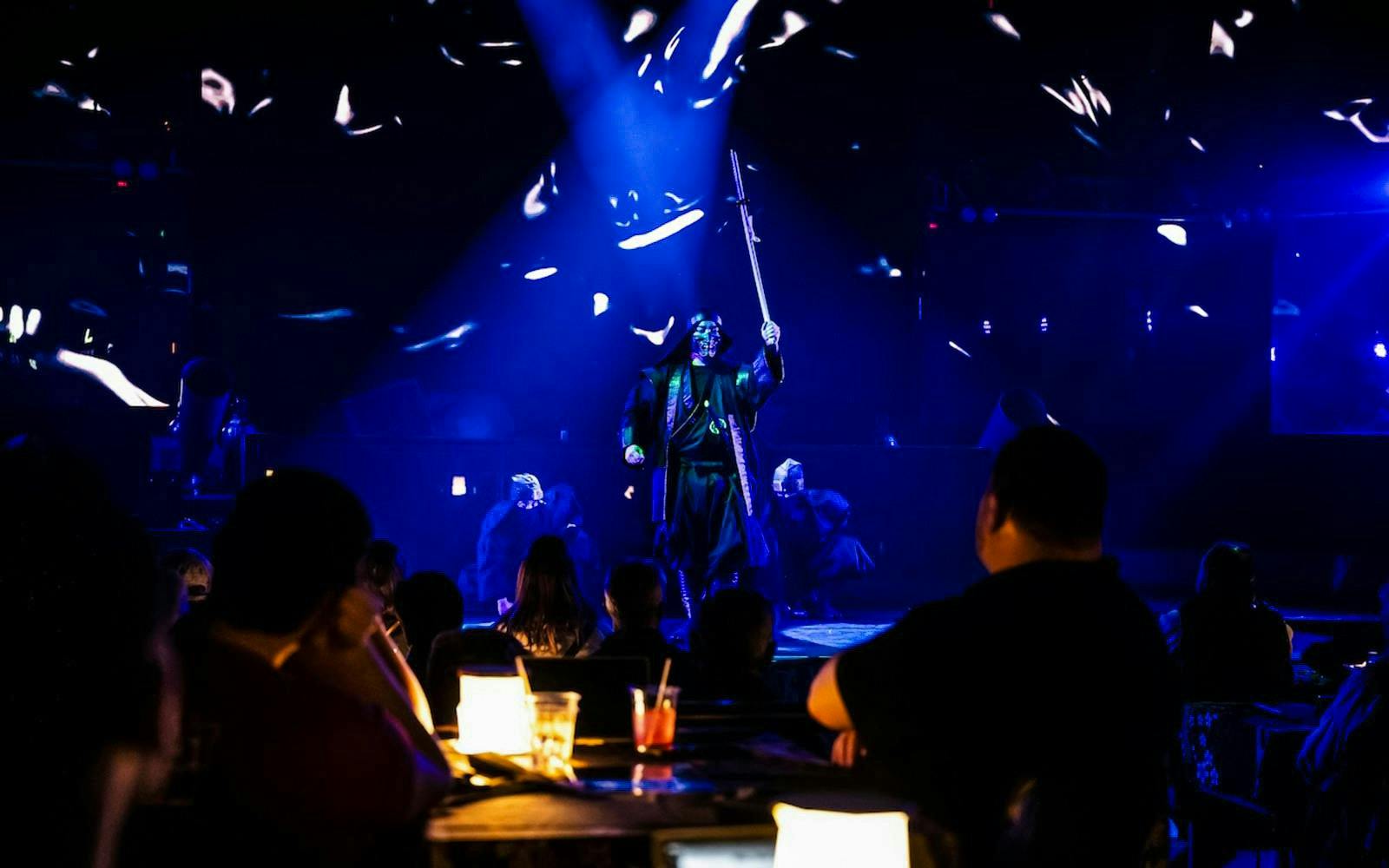 Ninja performing on stage with blue lights during Kabuki show in Shinjuku.