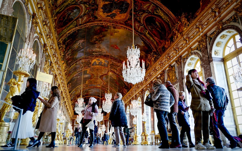 Visitors exploring the ornate Hall of Mirrors in Versailles King's State Apartments.
