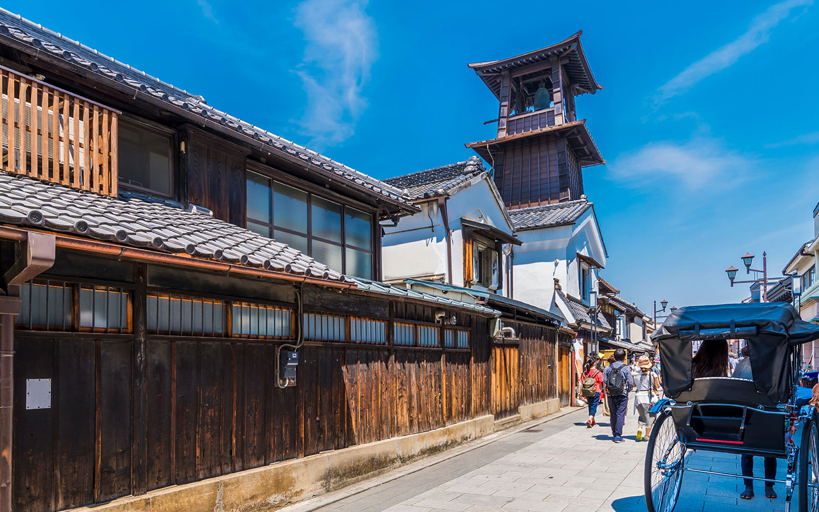 Traditional street in Karuizawa with wooden buildings and a rickshaw, Japan.