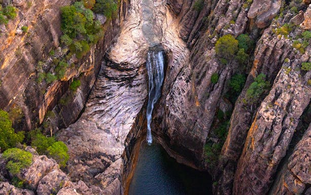 Aerial view of a waterfall flowing into a gorge in Kakadu National Park, Australia.