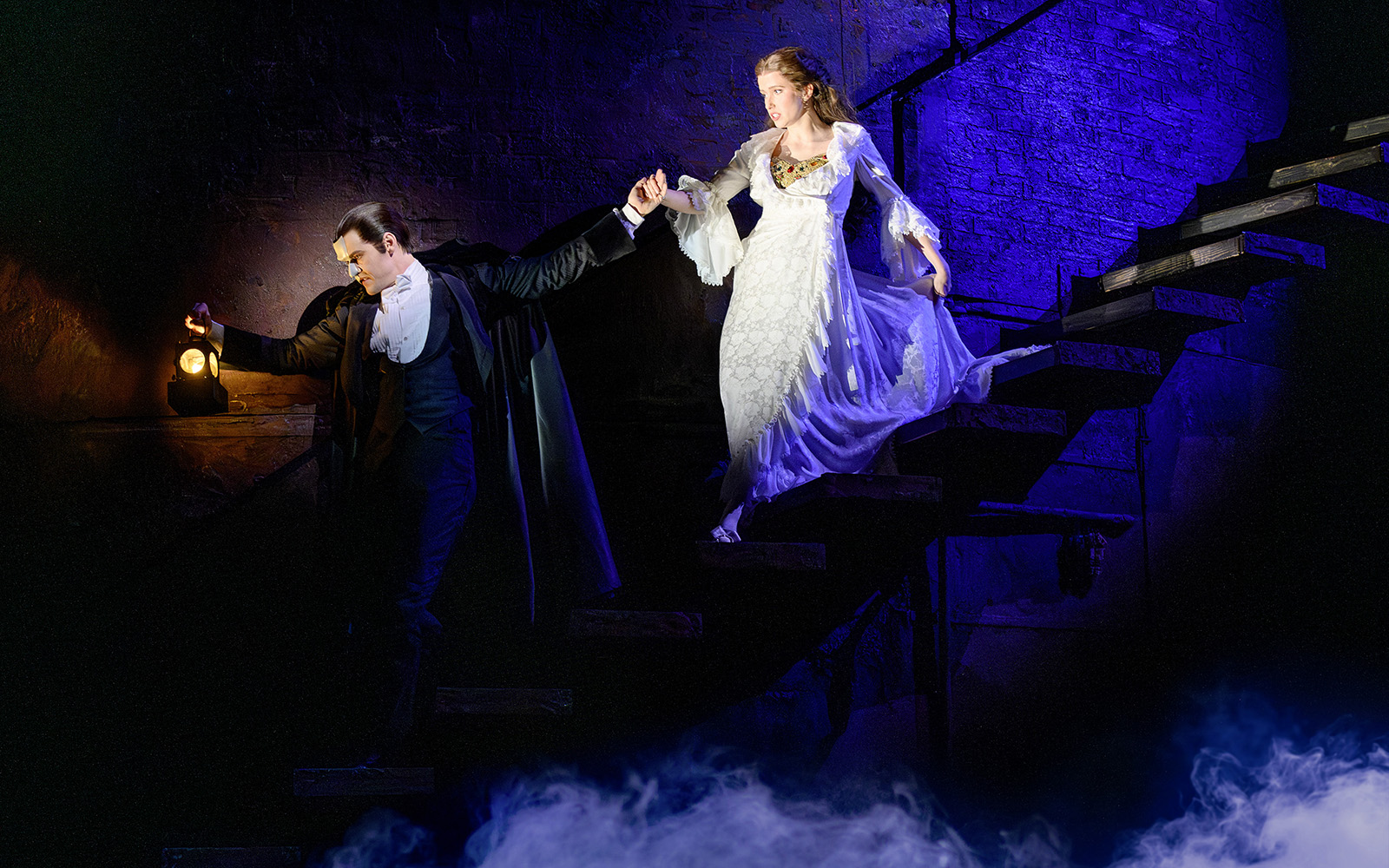Phantom leads Christine down stairs in Vienna's "The Phantom of the Opera" musical scene.