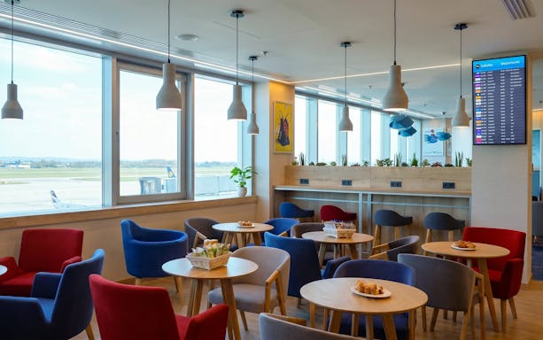 Seating area in Plaza Premium Lounge, Budapest Airport Terminal 2B, with runway view.
