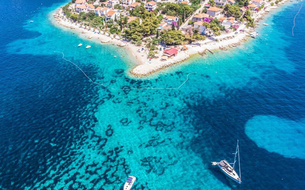 Aerial view of Duga Bay with boats and coastal village.