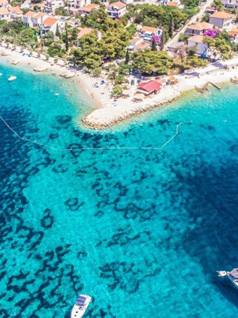 Aerial view of Duga Bay with boats and coastal village.